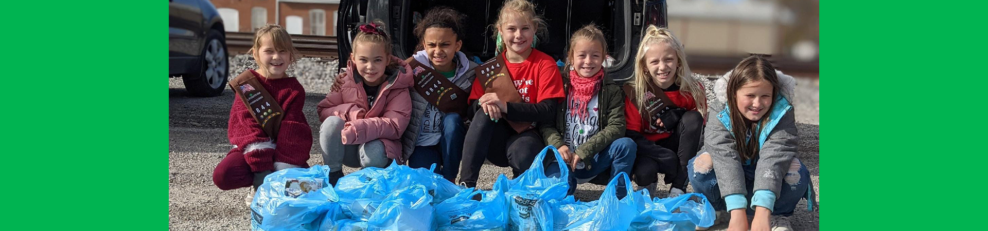  girl scouts posing with donated items 