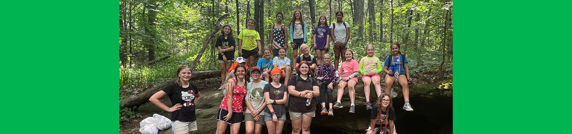  girl scouts posing together for a photo while on a hike in the woods 