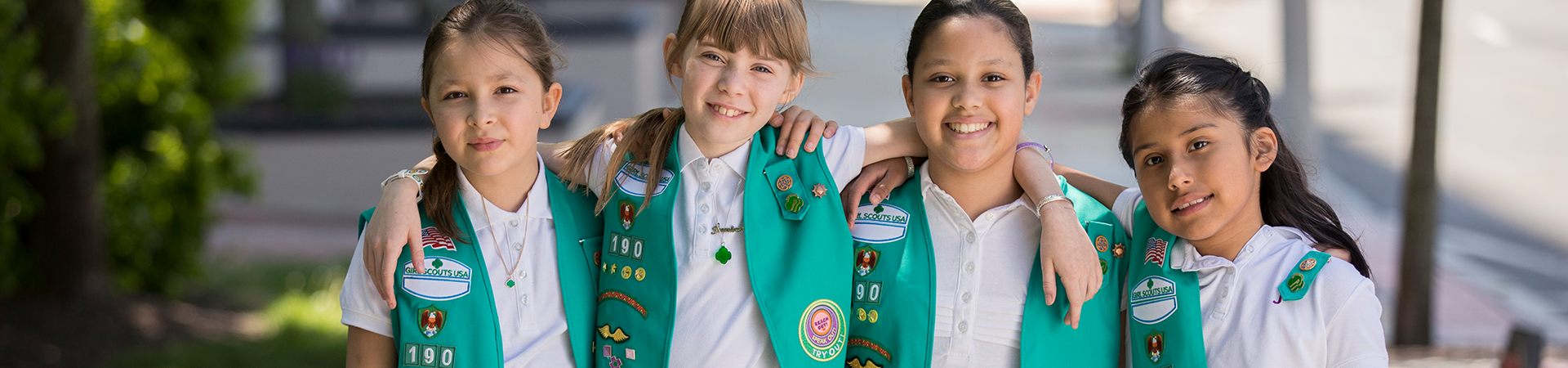  girl scout juniors posing with their arms around each other and smiling 