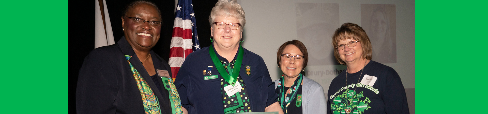  our CEO and board chair posing with an adult award winner at a recognition ceremony 